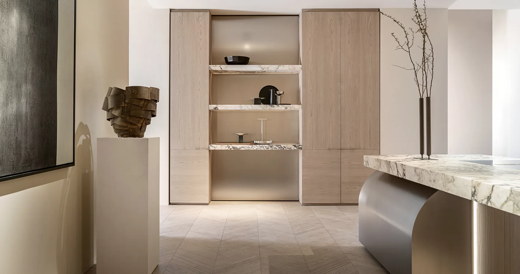Timber display cabinetry with stone shelves and concealed storage beside a sculptural stone and metal counter